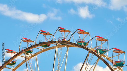 Panoramic picture of a Ferris wheel against blue sky.