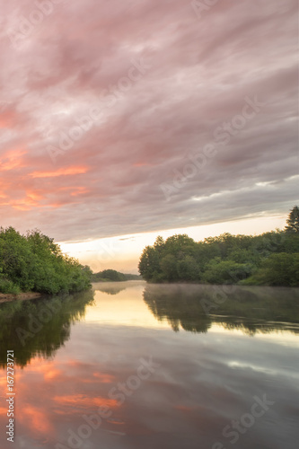 Fototapeta Naklejka Na Ścianę i Meble -  Summer landscape scenic fiery sunset over calm river