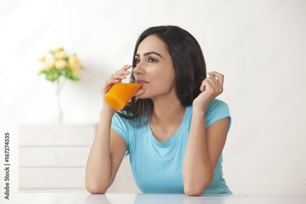 Beautiful young woman drinking orange juice at home Beautiful young woman drinking orange juice at home