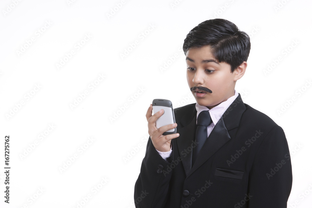 Boy dressed as businessman looking at sms on mobile phone Boy dressed as businessman looking at sms on mobile phone
