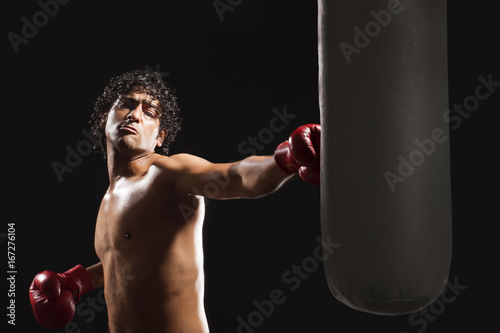 Male boxer hitting heavy bag 