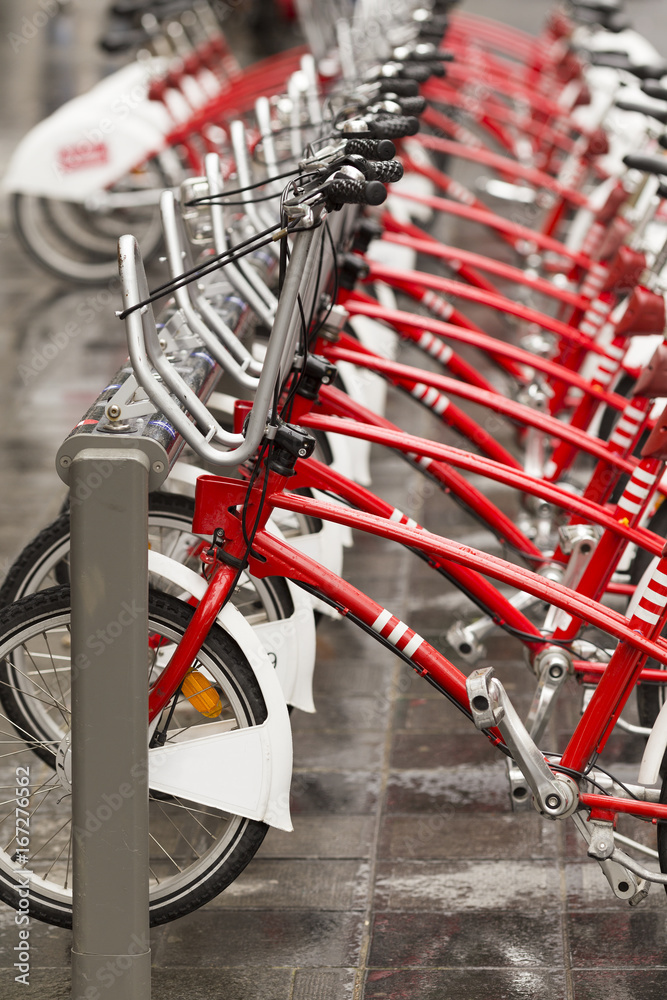 Red bikes standing in a row at bicycle-sharing system