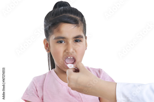 Portrait of little girl having medicine