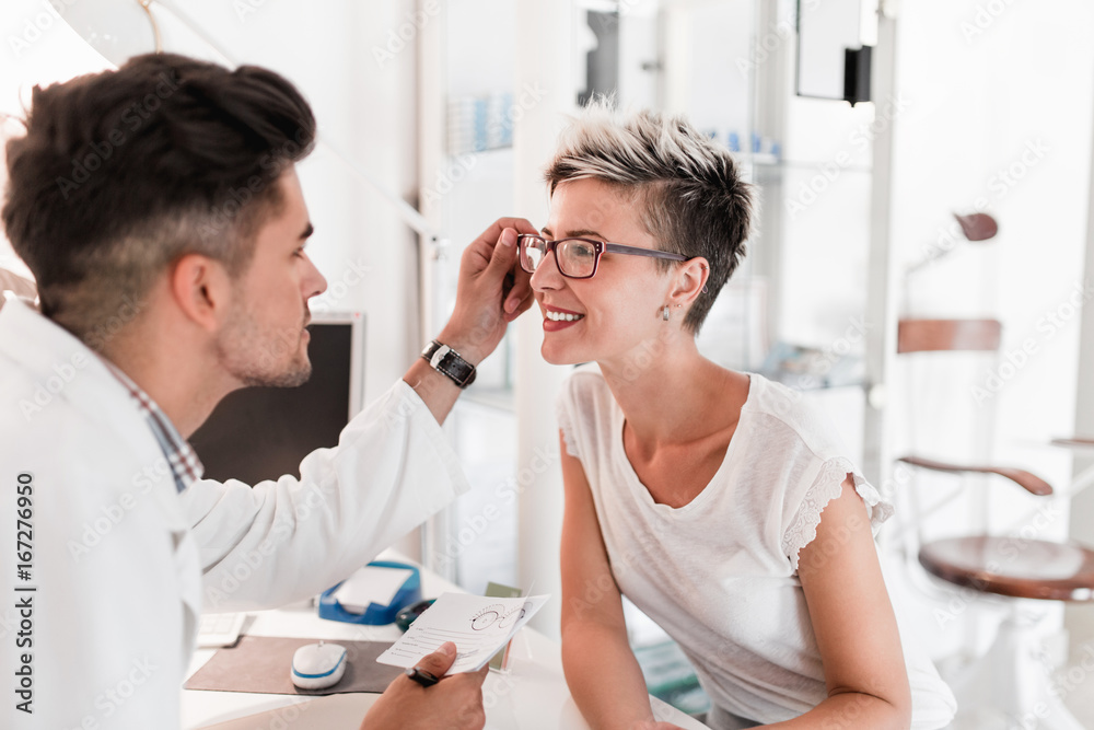 Male optometrist checking patient's vision at eye clinic. Male optometrist checking patient's vision at eye clinic.