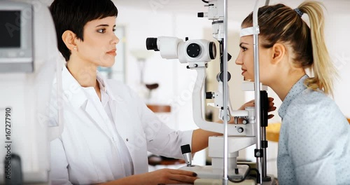 Patient or customer at slit lamp at optometrist or optician photo