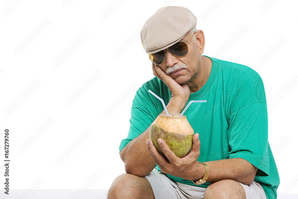 Fototapeta premium Old man with a coconut drink 