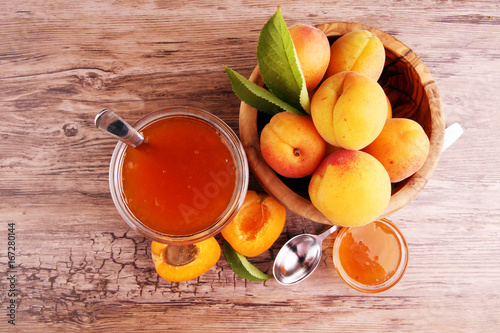 Apricot jam in glass bowl with fruit around