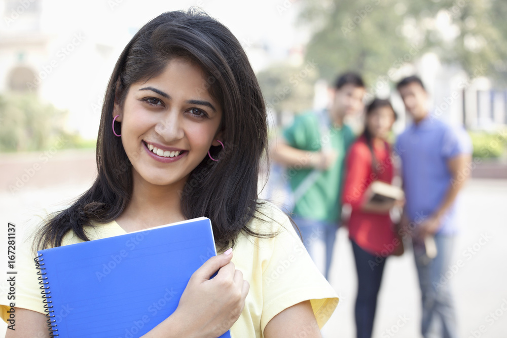 Close-up portrait of smiling young woman with friends in the background 