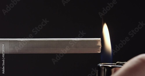 Person lights cigarette with lighter, close up