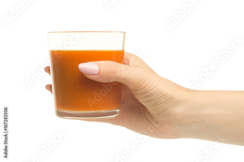 A glass of carrot-apple juice in a woman's hand