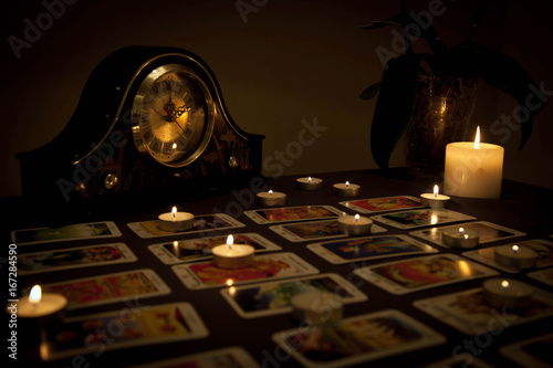 Mystic fortune-telling with fired candles and playing cards in d
