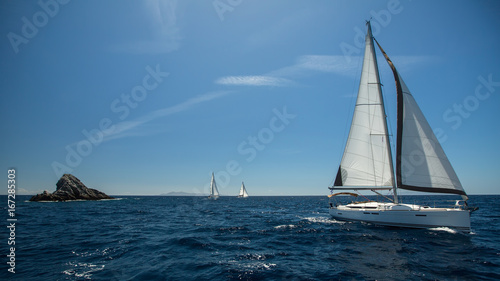 Sailing in the wind through the waves. Luxury yachts at Regatta on Aegean Sea.