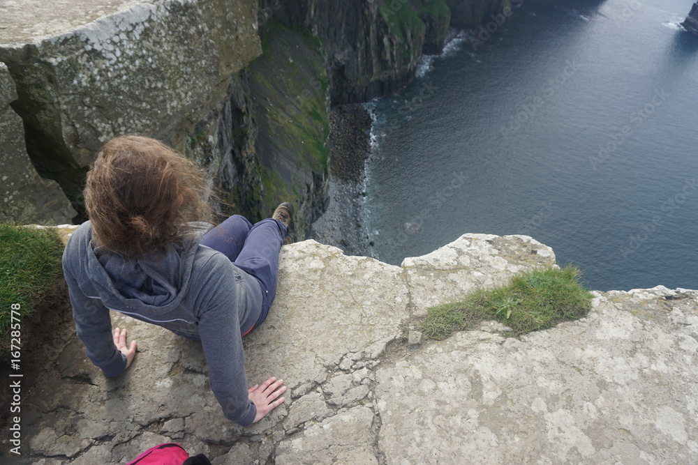A girl sitting on the edge of a cliff, Cliffs of Moher, Ireland