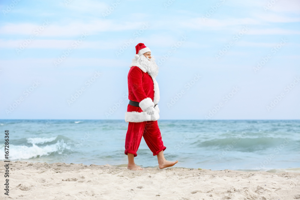 Authentic Santa Claus walking on beach Authentic Santa Claus walking on beach