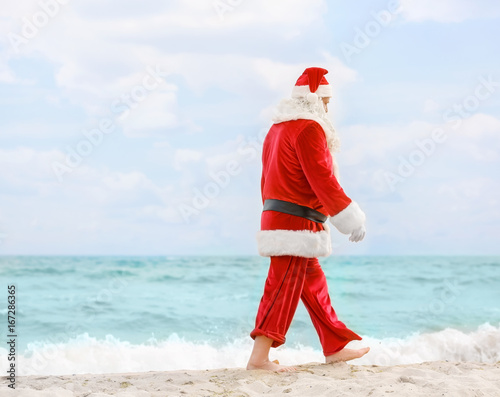 Authentic Santa Claus walking on beach