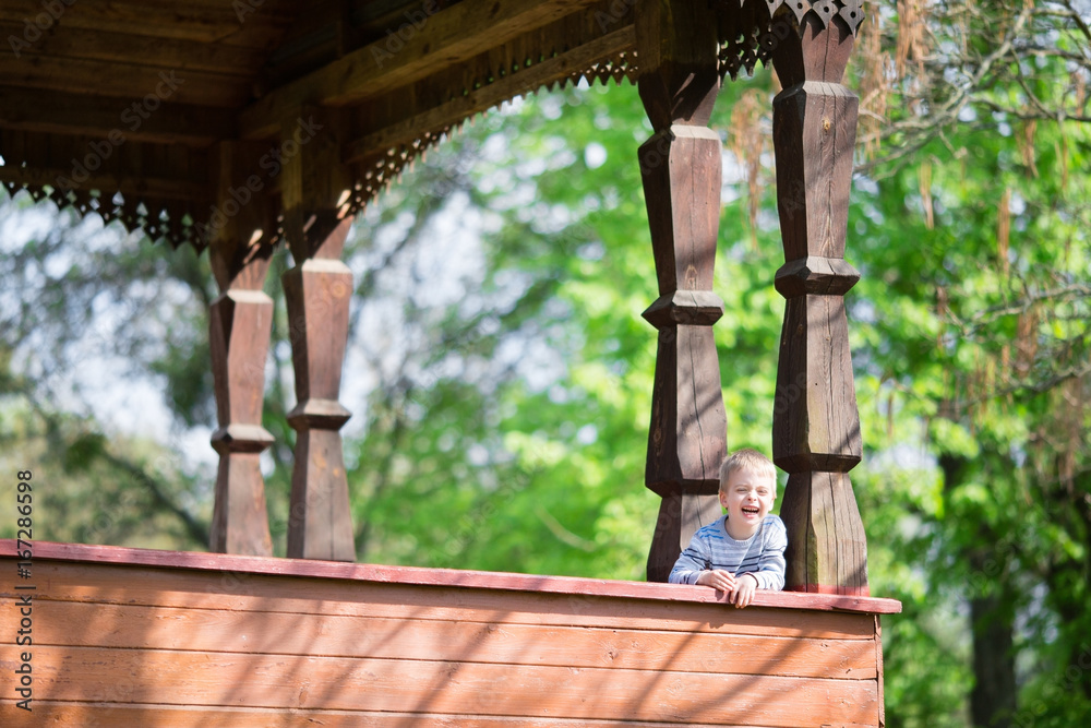 Happy little boy laughing in nature. Museum of Folk Architecture and Life of Ukrainians in Pereyaslav-Khmelnitsky Happy little boy laughing in nature. Museum of Folk Architecture and Life of Ukrainians in Pereyaslav-Khmelnitsky