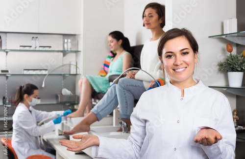 Young nail salon master inviting clients to procedure