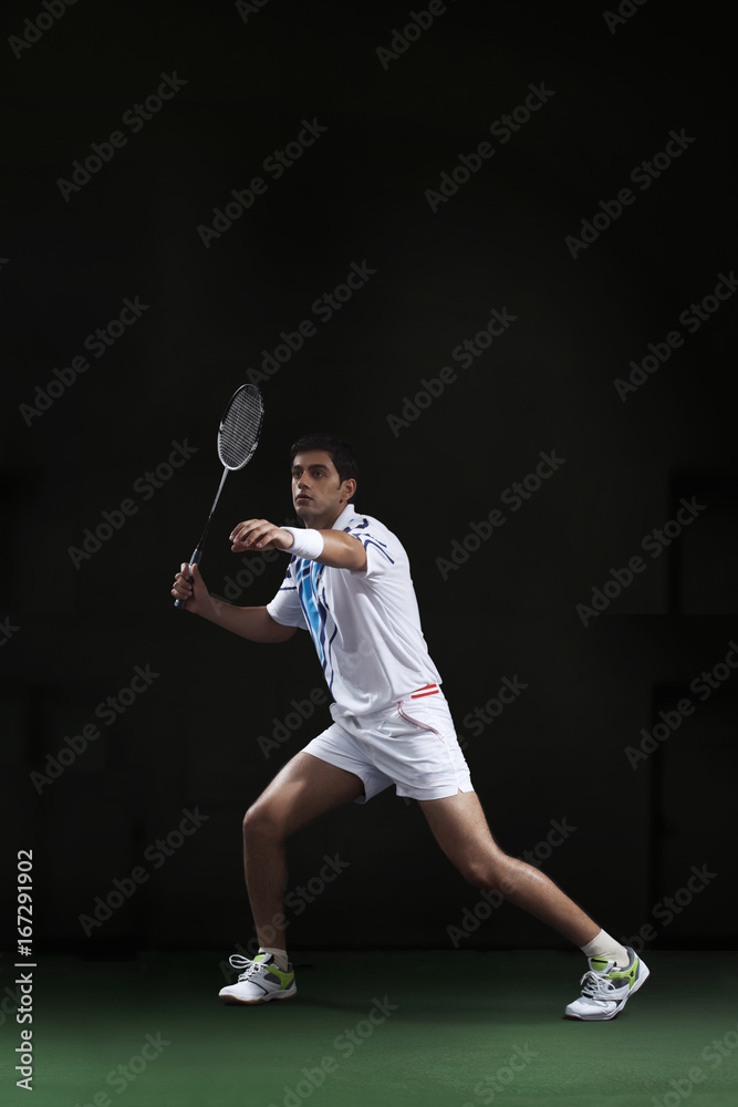 Full length of man holding badminton racket at court Full length of man holding badminton racket at court