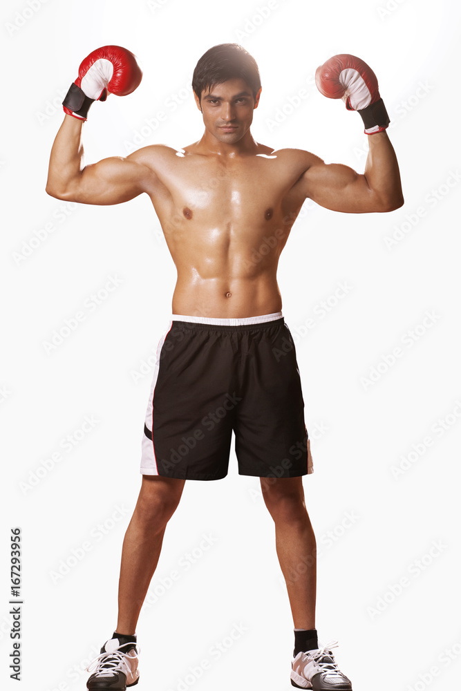 Full length portrait of young male boxer flexing muscles isolated over white background Full length portrait of young male boxer flexing muscles isolated over white background