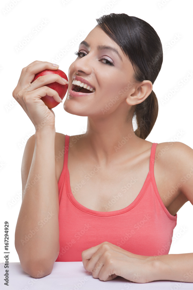Portrait of smiling young woman with fresh apple over white background Portrait of smiling young woman with fresh apple over white background