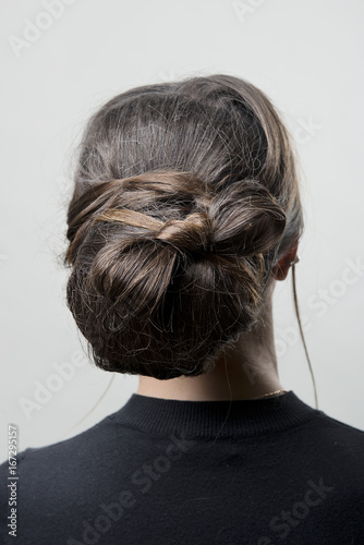 hairstyle bun on the brunette on isolated light background