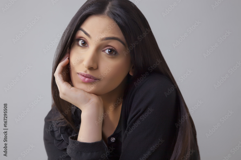 Portrait of a bored young woman with hand on chin isolated over colored background Portrait of a bored young woman with hand on chin isolated over colored background