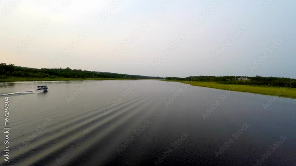 Alaska 4k  aerial birds eye view drone tracking shot of of glass calm Alaska Moose River with power fishing boat turning away and heading home as shot goes over the boat and toward the shore.