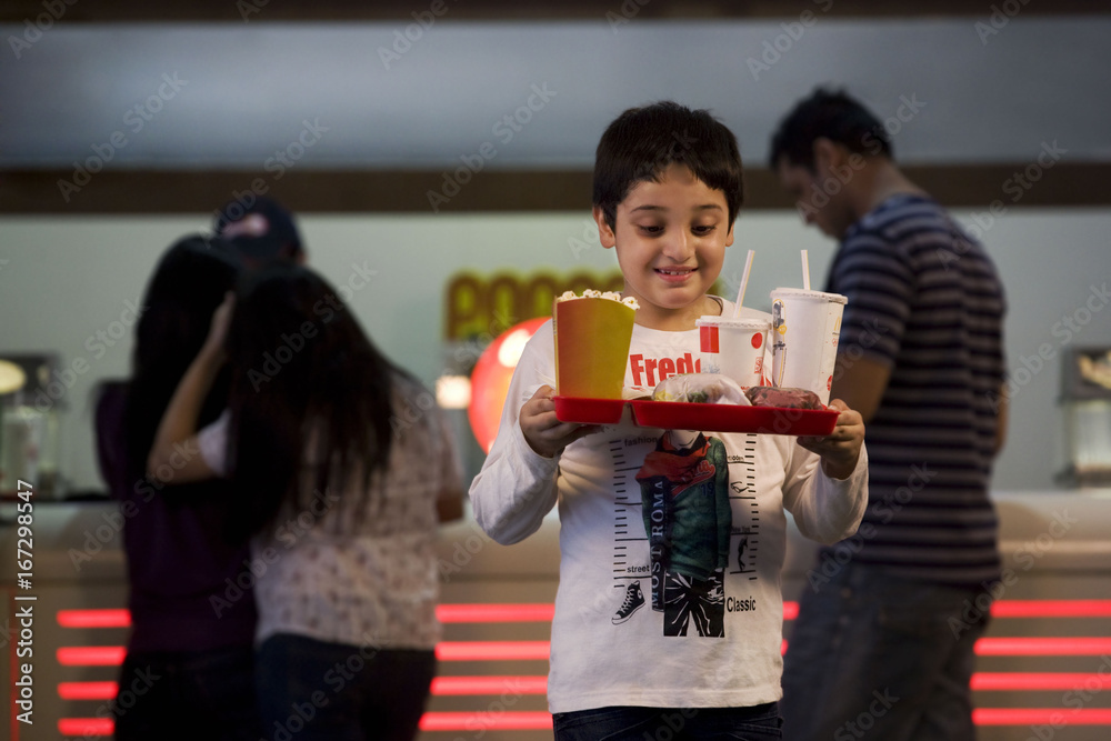 Obraz premium Boy carrying cola and popcorn 