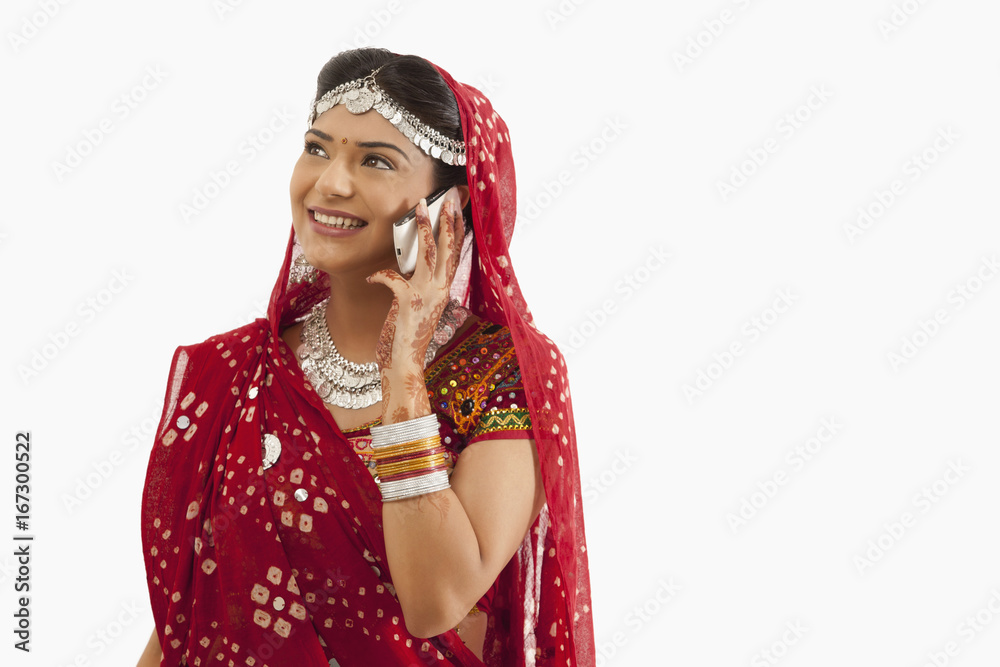 Female dandiya dancer talking on a mobile phone Female dandiya dancer talking on a mobile phone