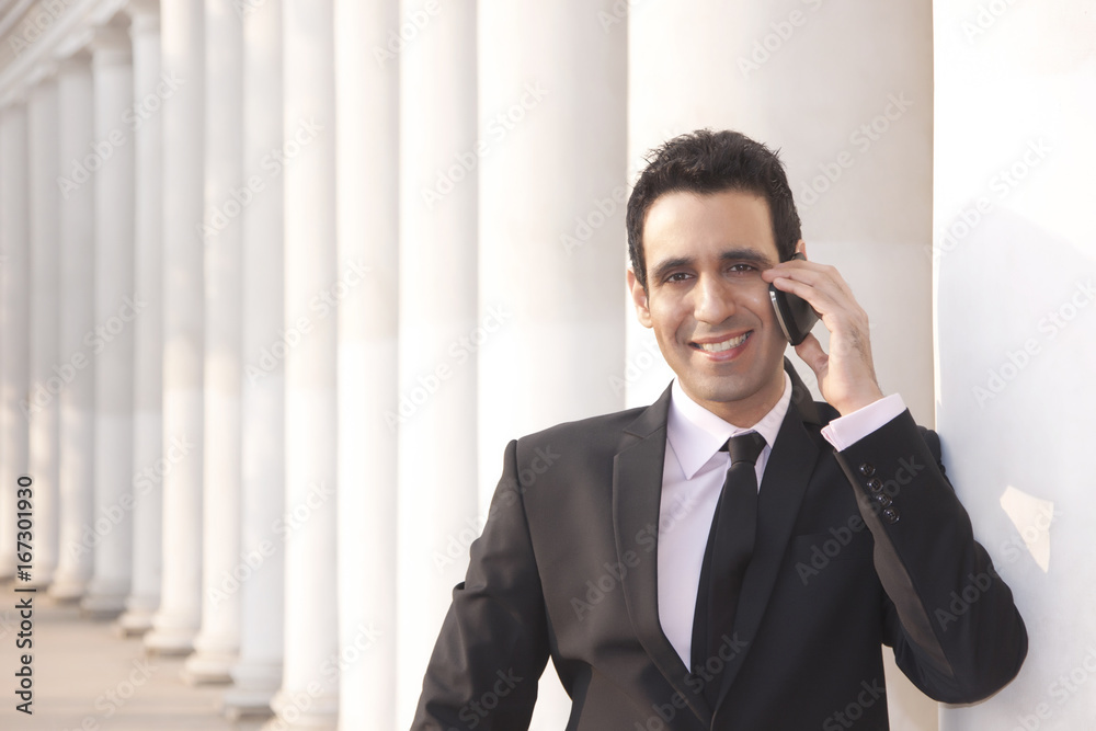 Portrait of a businessman talking on a mobile phone , INDIA , DELHI Portrait of a businessman talking on a mobile phone , INDIA , DELHI