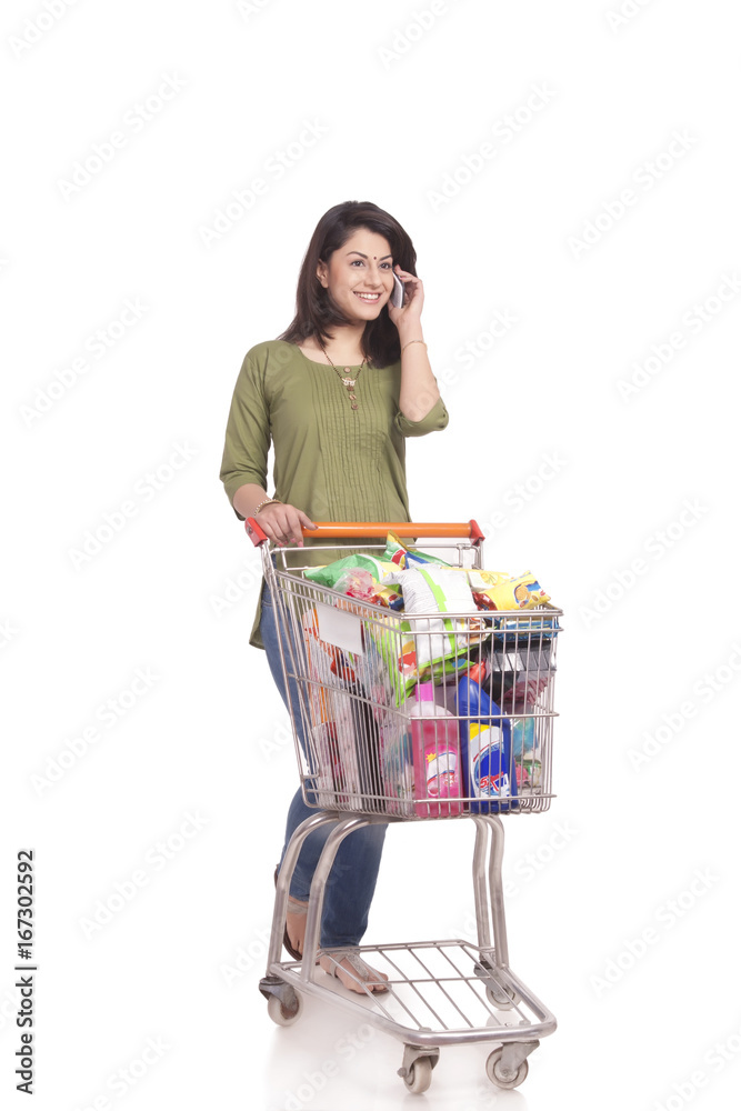 Married woman with shopping cart talking on mobile phone Married woman with shopping cart talking on mobile phone