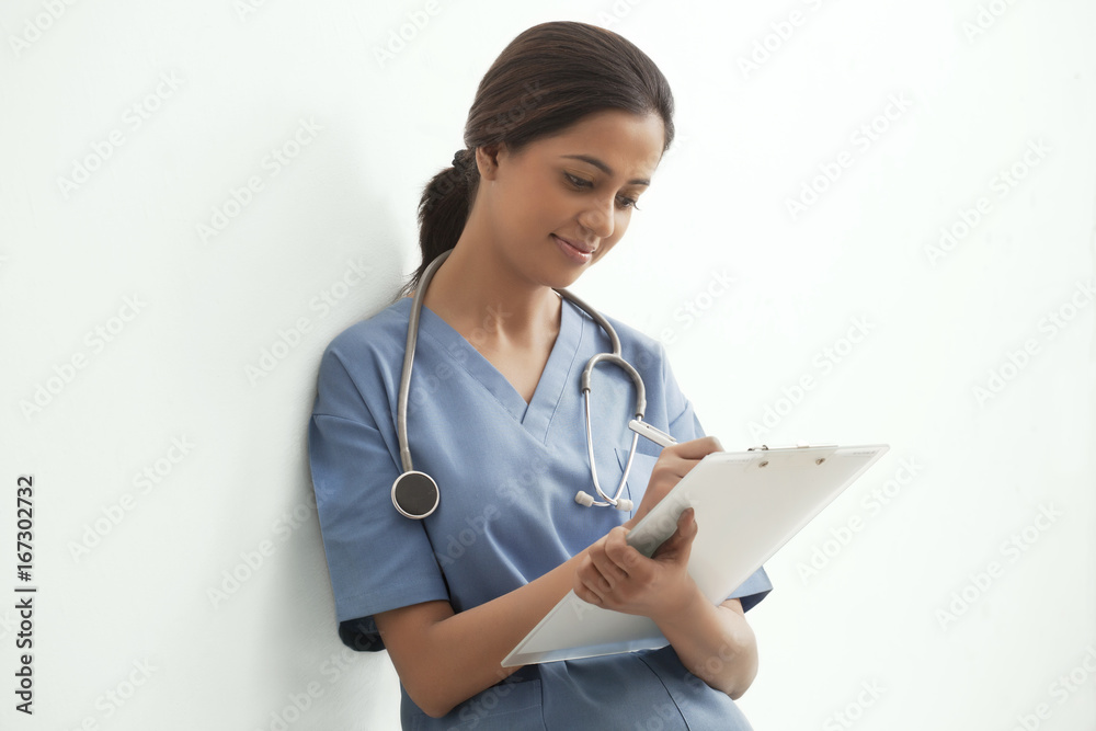 Young female surgeon writing notes isolated over white background Young female surgeon writing notes isolated over white background