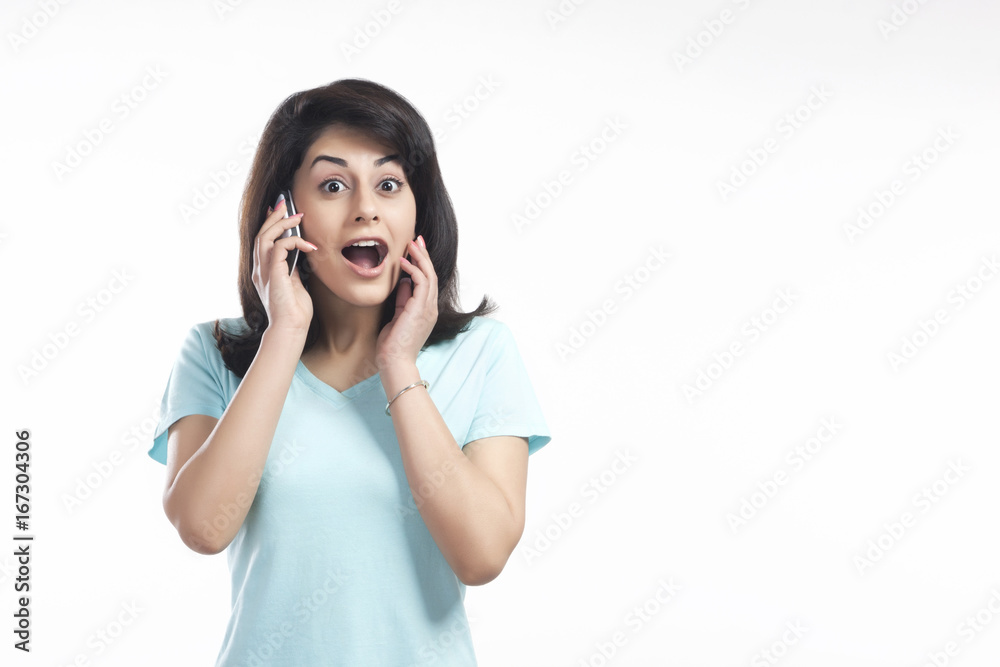 Woman shocked while talking on a mobile phone Woman shocked while talking on a mobile phone