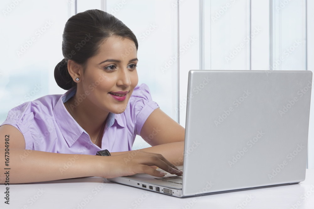 Beautiful businesswoman using laptop at office desk Beautiful businesswoman using laptop at office desk