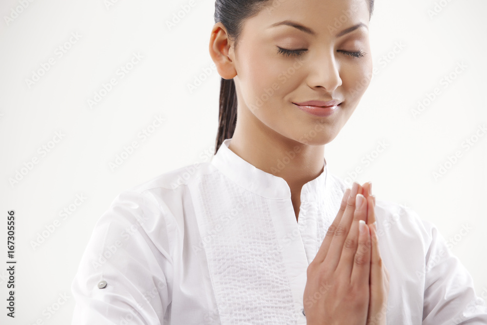 Smiling woman with hands clasped practicing yoga Smiling woman with hands clasped practicing yoga
