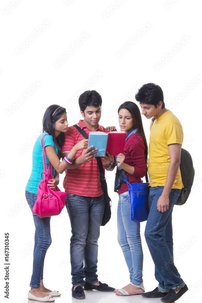 Full length of college friends reading book against white background Full length of college friends reading book against white background