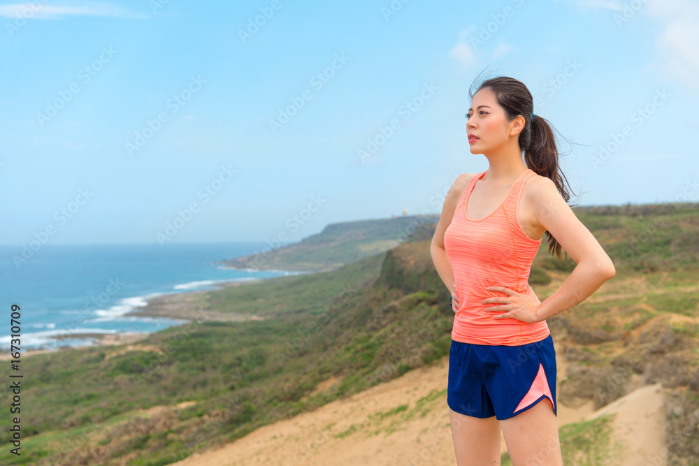 beautiful woman standing on coastal mountain