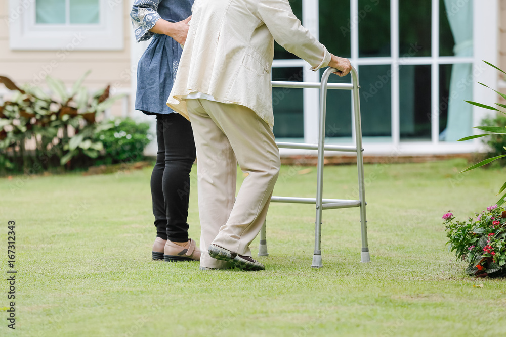 Fototapeta premium Elderly woman exercise walking in backyard with daughter