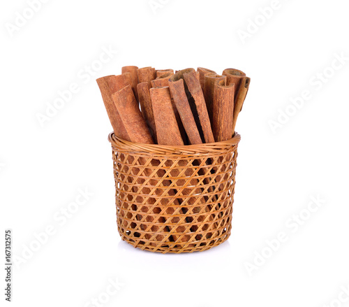 dried cinnamon in basket and on white background