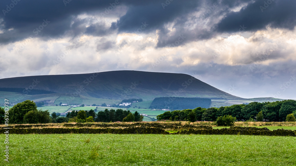 Obraz premium Distance view from farm on Pendle Hill on cloudy summer afternoon