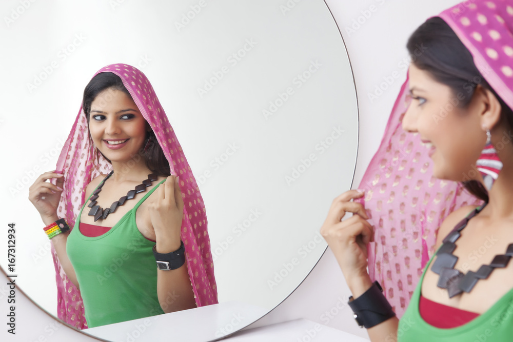Young woman looking at herself in the mirror Young woman looking at herself in the mirror