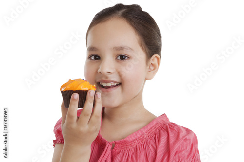 Portrait of a little girl eating a cupcake