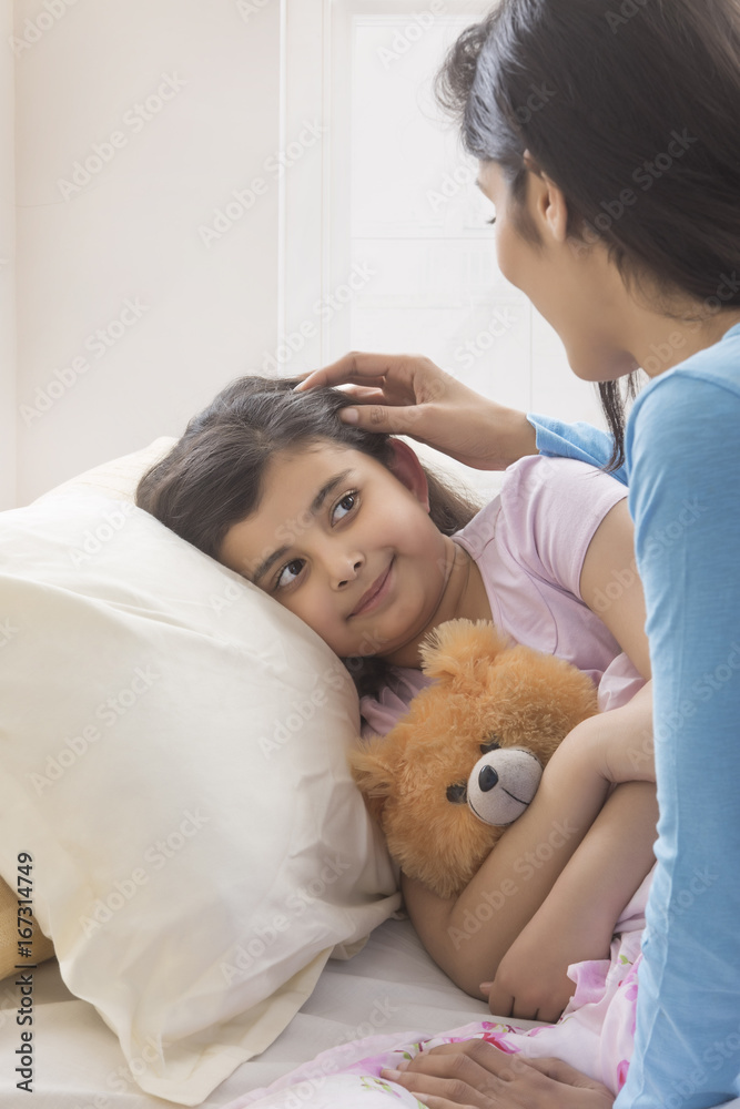 Mother looking at sleeping daughter in bed Mother looking at sleeping daughter in bed