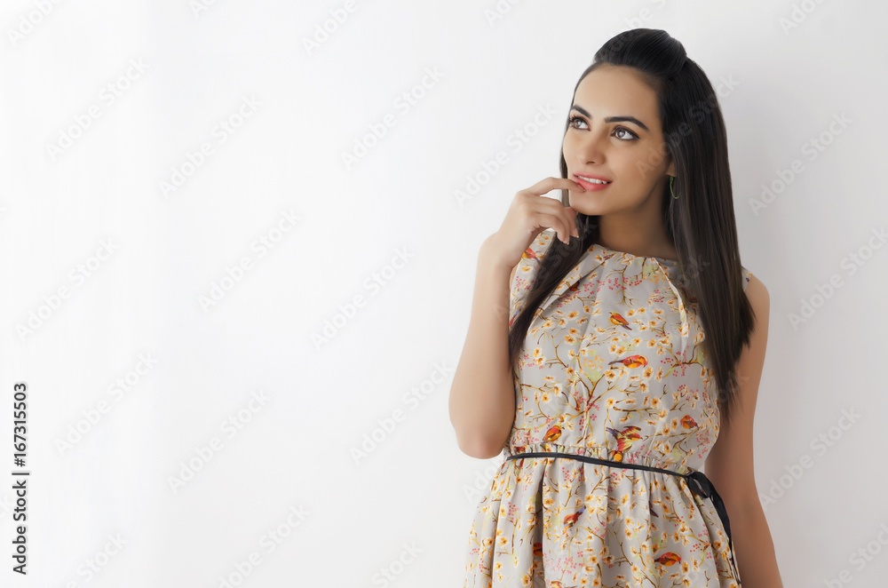 Thoughtful young woman wearing sundress looking at copy space on white background Thoughtful young woman wearing sundress looking at copy space on white background