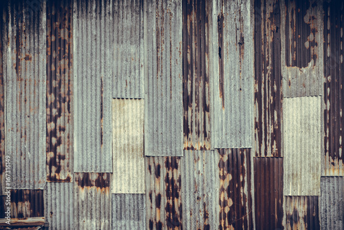 Old rusty corrugated tin zinc metal wall in vintage tone. © pookpiik