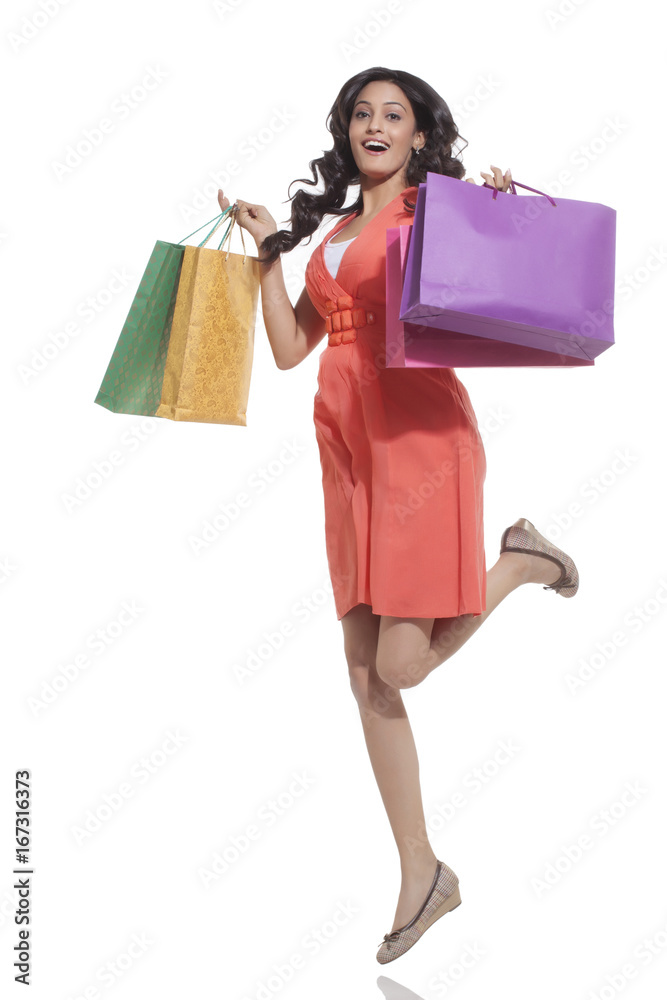 Portrait of a woman jumping with shopping bags Portrait of a woman jumping with shopping bags