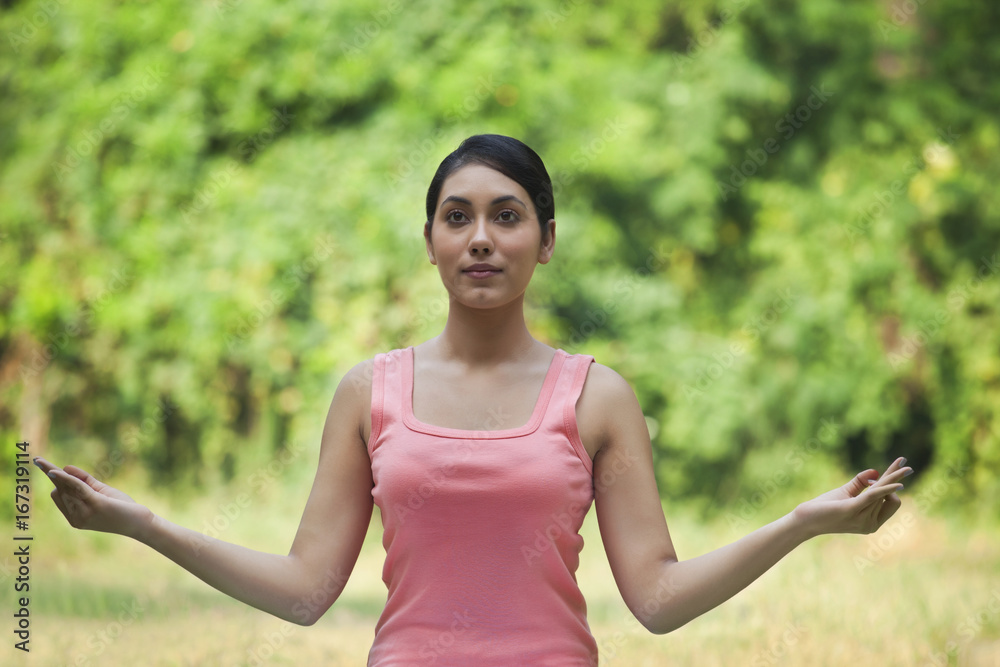 Woman in lawn practicing yoga and looking away Woman in lawn practicing yoga and looking away