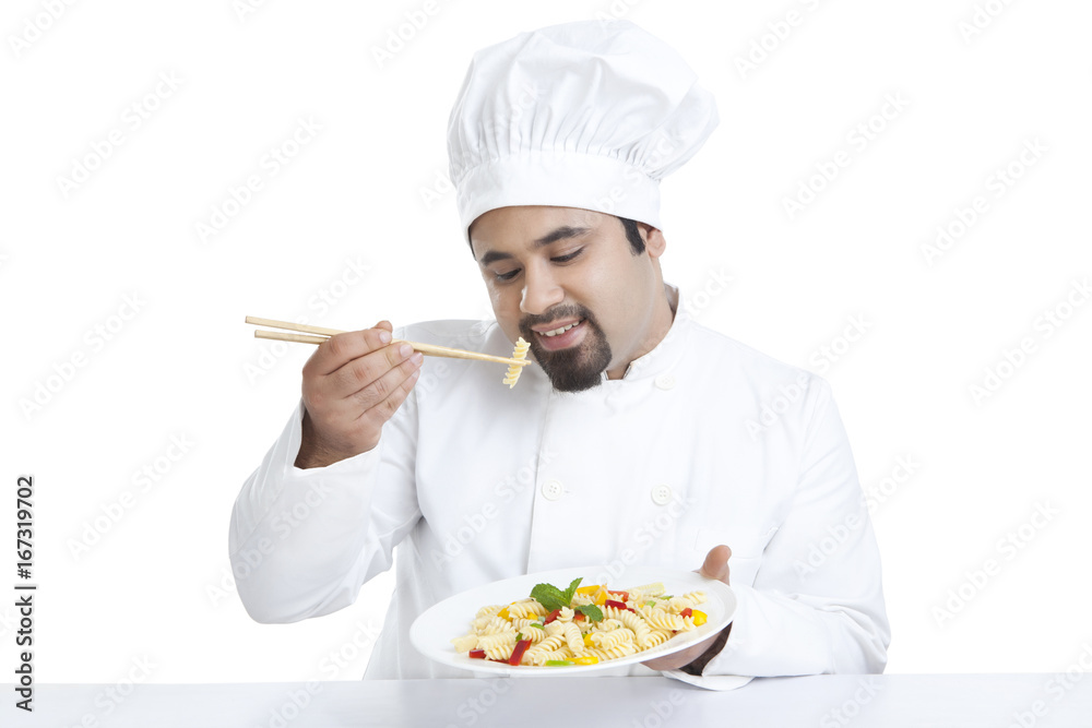 Chef eating pasta with chopsticks Chef eating pasta with chopsticks
