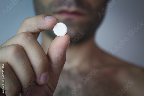 Man holding a pill.