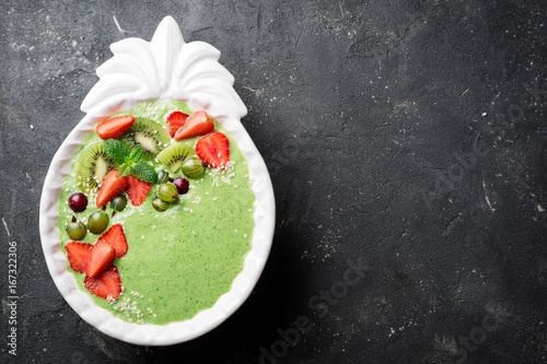 Smoothie bowl with kiwi, spinach, strawberries and berry. Green smoothie detox. Healthy eating diet concept